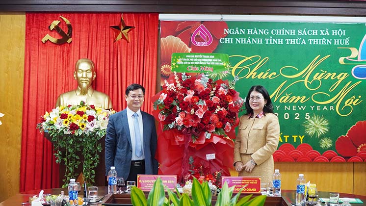 Phó Chủ tịch Thường trực UBND tỉnh, Trưởng Ban đại diện NHCSXH tỉnh Nguyễn Thanh Bình tặng hoa chúc mừng Chi nhánh NHCSXH tỉnh