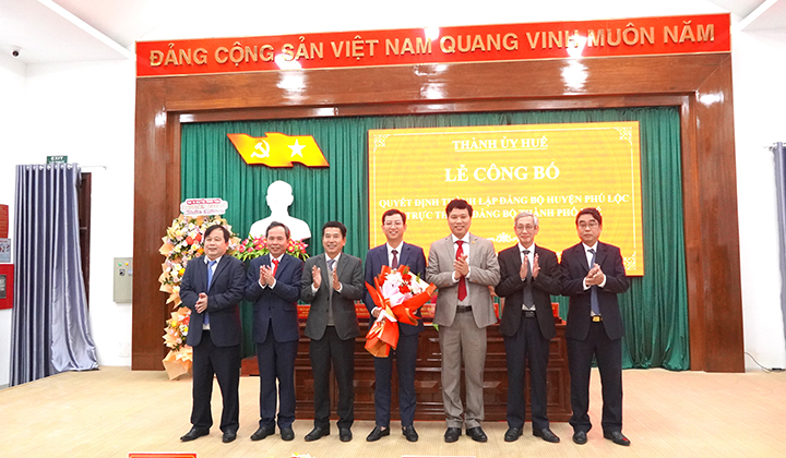 Ông Phan Xuân Toàn, Trưởng Ban Tổ chức Thành ủy; ông Đặng Ngọc Trân, Trưởng Ban Nội chính Thành ủy trao quyết định và tặng hoa chúc mừng